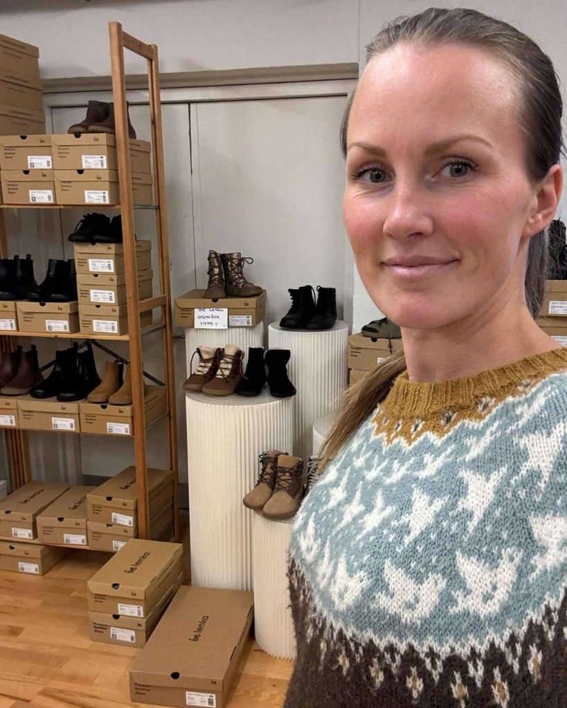 Freya in the showroom among Be Lenka boxes and displayed barefoot shoes